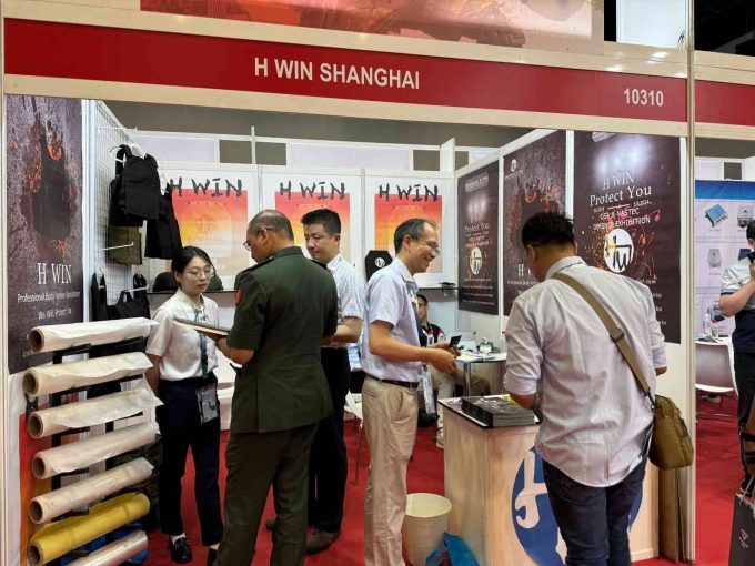 H Win's booth at a trade show, showcasing their bulletproof vests and materials