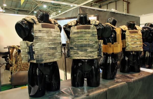 Different sizes of tactical vests and plate carriers displayed on mannequins